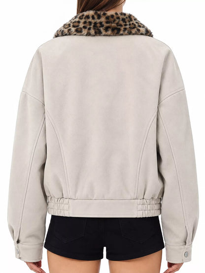 A person shown from the back wearing a light beige cropped jacket with a leopard-print faux-fur collar and black shorts against a plain white background.
