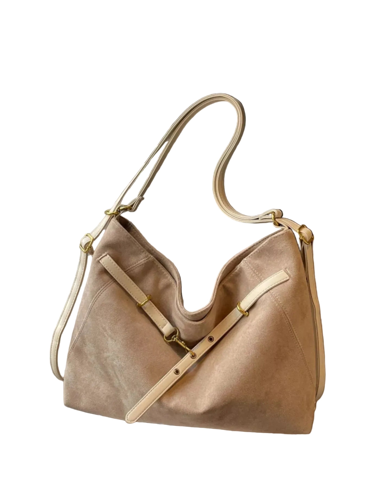 A beige suede slouchy shoulder bag with cream leather straps and gold-tone hardware, resting on a surface in front of window blinds.