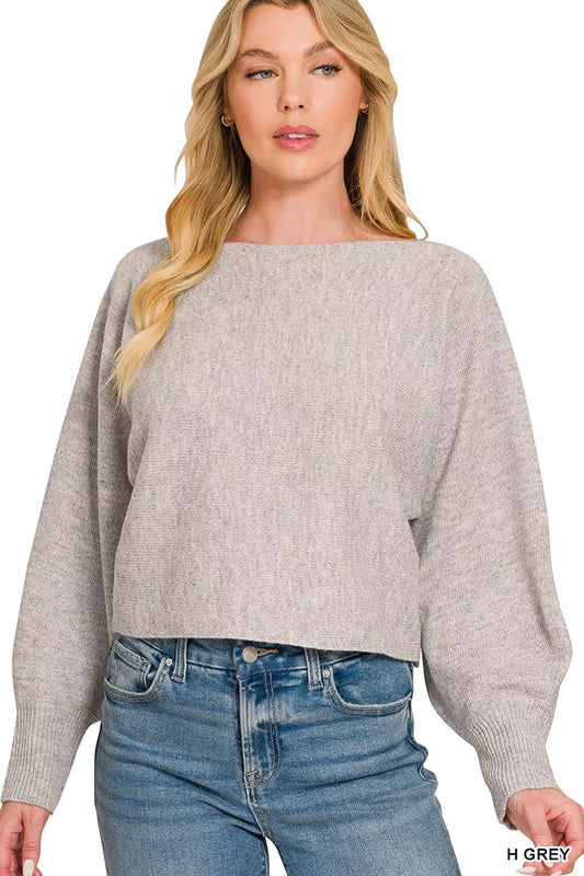 Woman wearing a gray sweater and blue jeans on a white background
