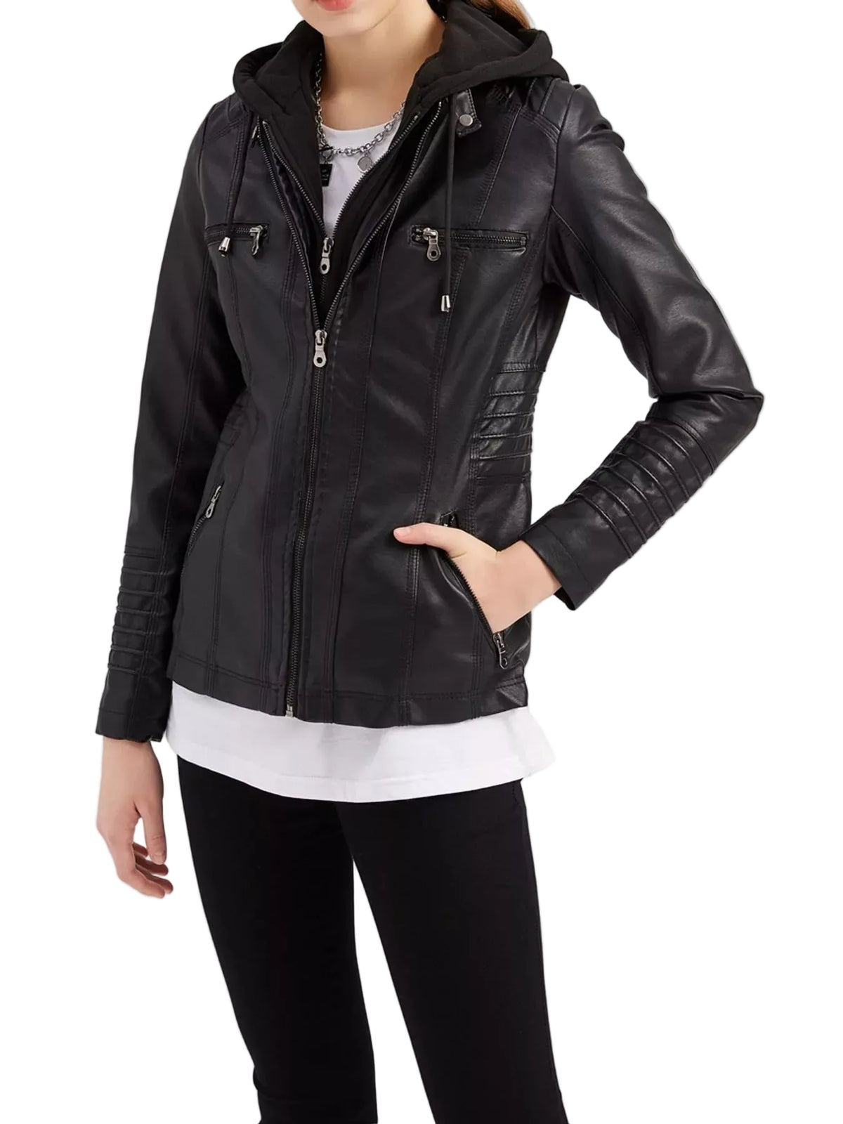 A woman wearing a black faux-leather hooded jacket with multiple zippered pockets, styled over a white shirt and black pants against a plain white studio background.