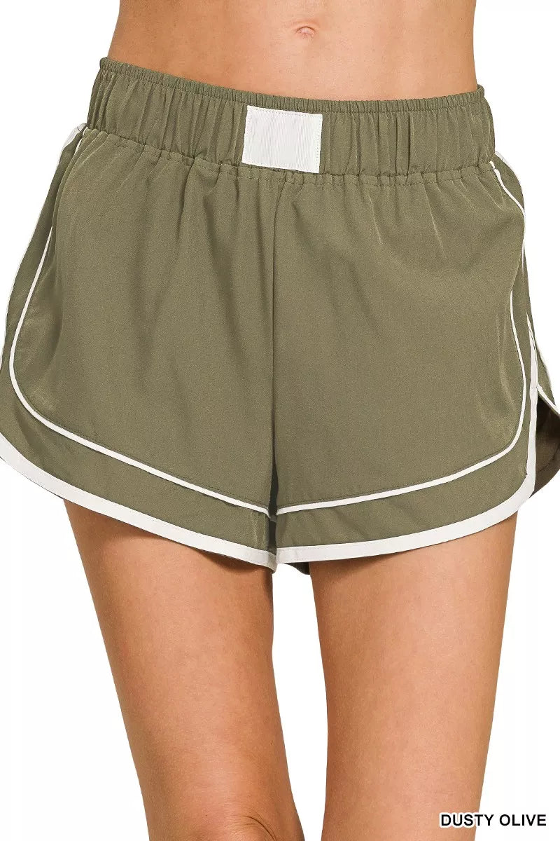 Olive green shorts with white trim on a white background