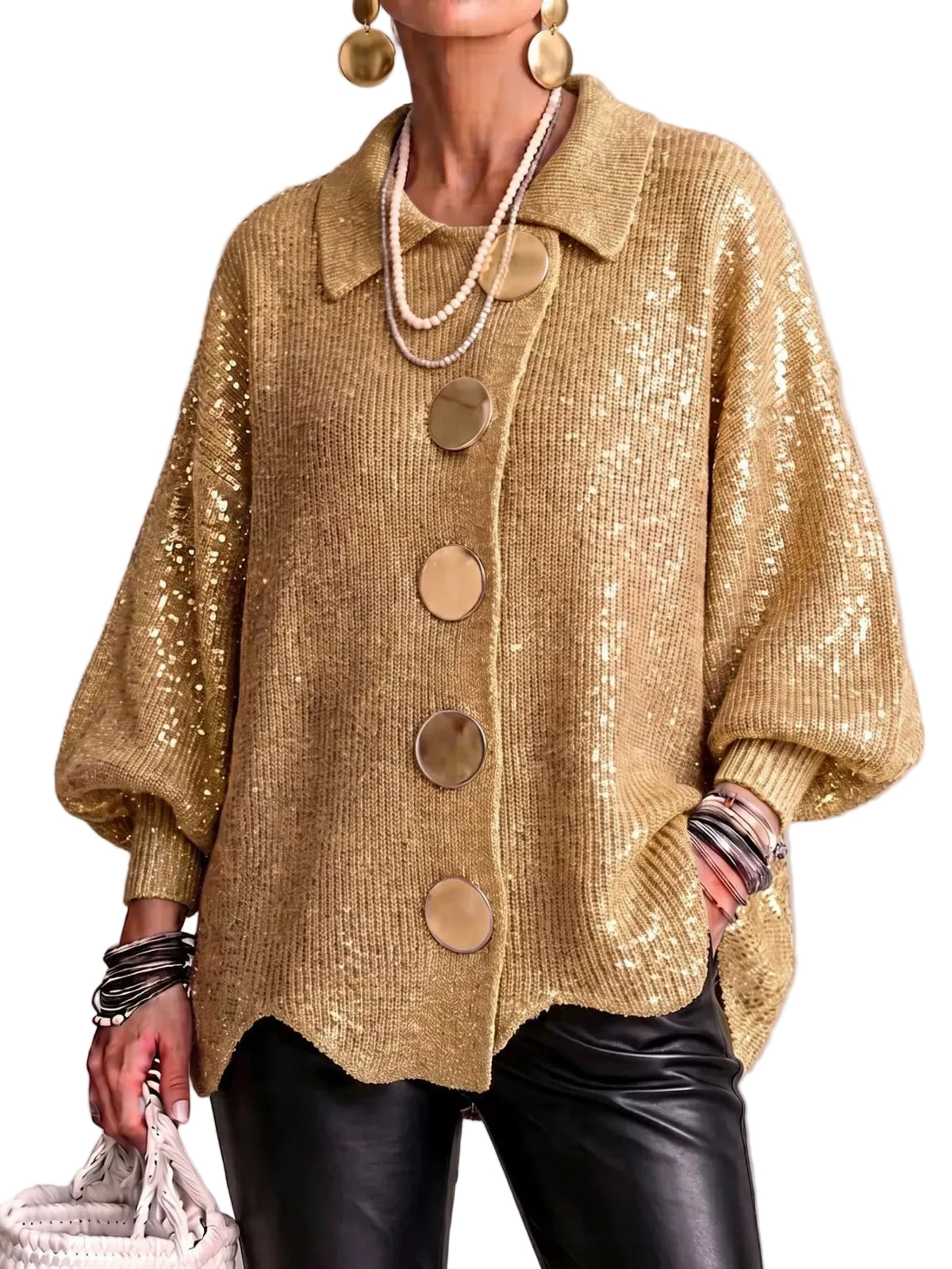 A woman wearing a gold sequined knit cardigan with oversized buttons, styled with black leather pants, layered pearl necklaces, and gold earrings against a neutral gray background.