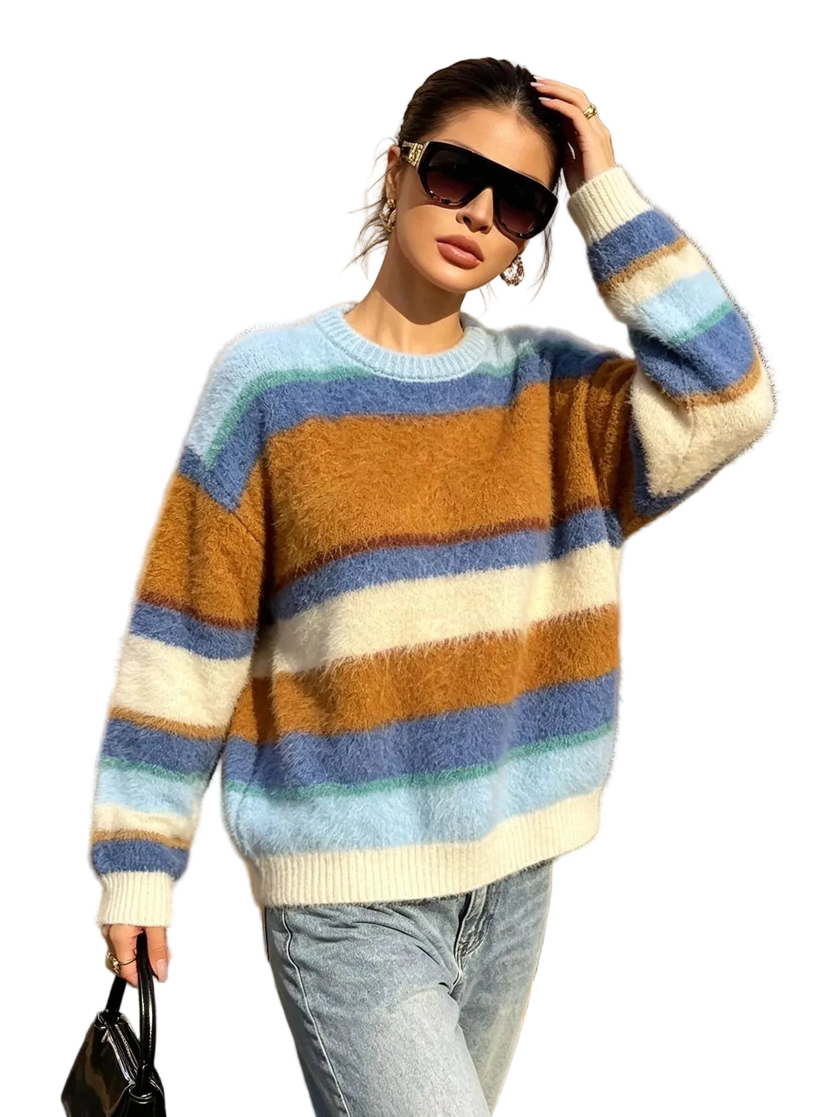 A woman wearing a fuzzy, long-sleeve striped knit sweater with horizontal bands of light blue, mustard brown, cream, and dusty blue, paired with light-wash jeans, standing on a city sidewalk.