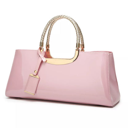 Pink handbag with gold handle and accents on a white background