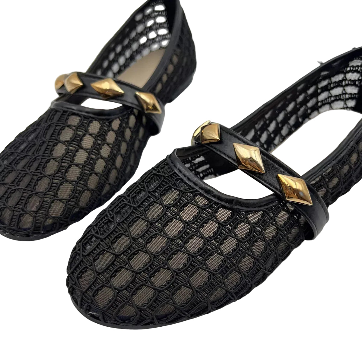 A pair of black crochet mesh Mary Jane flats with glossy black straps and gold pyramid stud embellishments, shown on a light gray background.