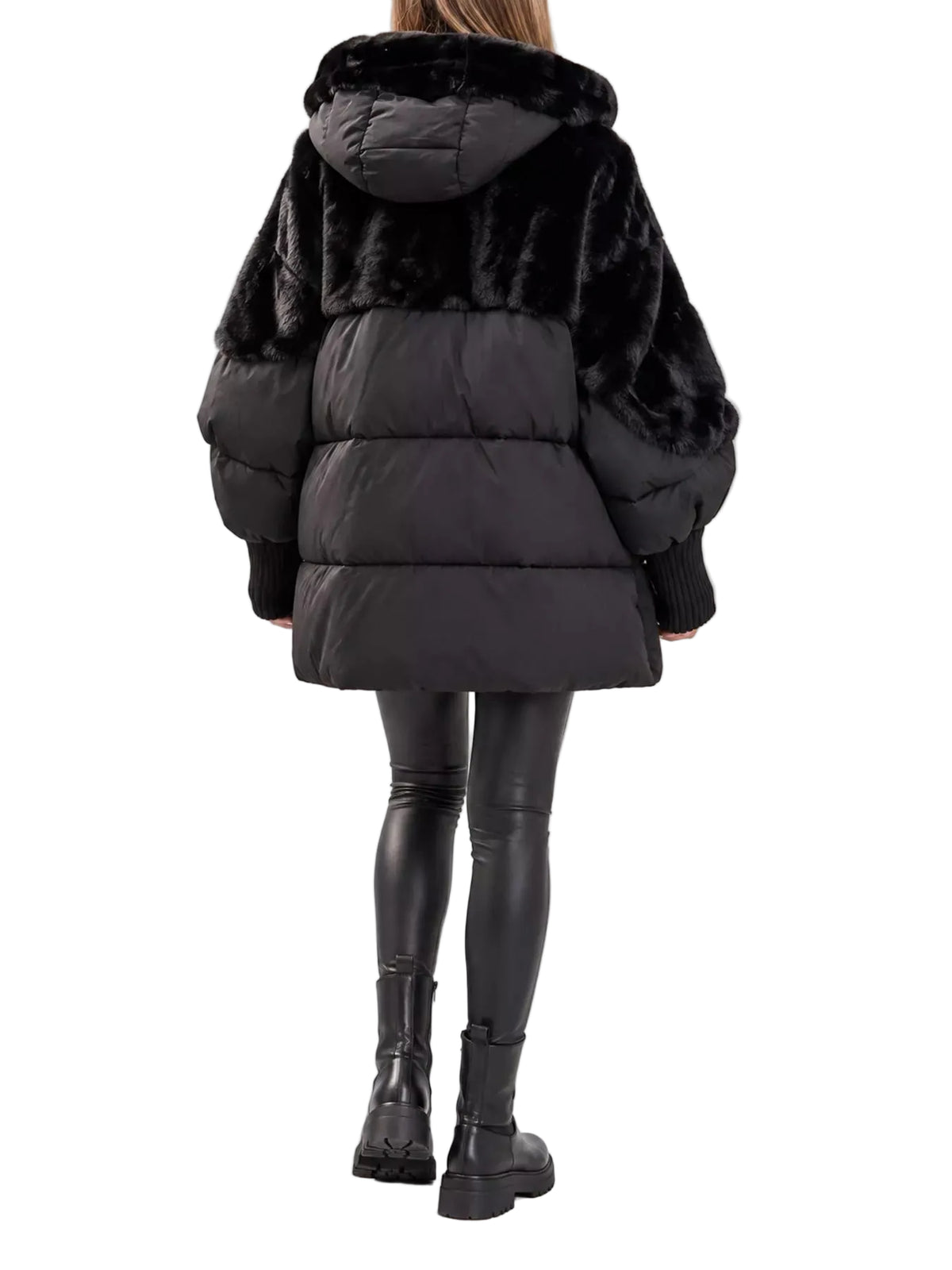 A model viewed from the back wearing a black puffer jacket with a faux-fur collar and sleeves, paired with black leggings and black boots, against a light gray studio background.