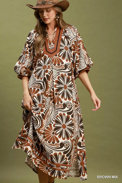 Woman wearing a patterned dress with a brown hat against a green background