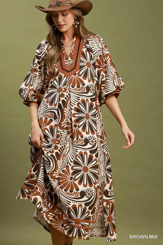Woman wearing a patterned dress with a brown hat against a green background