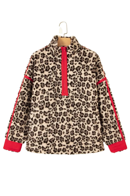 A fuzzy leopard-print quarter-zip sweatshirt with bright red contrast panels on the front placket and sleeve cuffs, hanging on a wooden hanger against a plain off-white background.