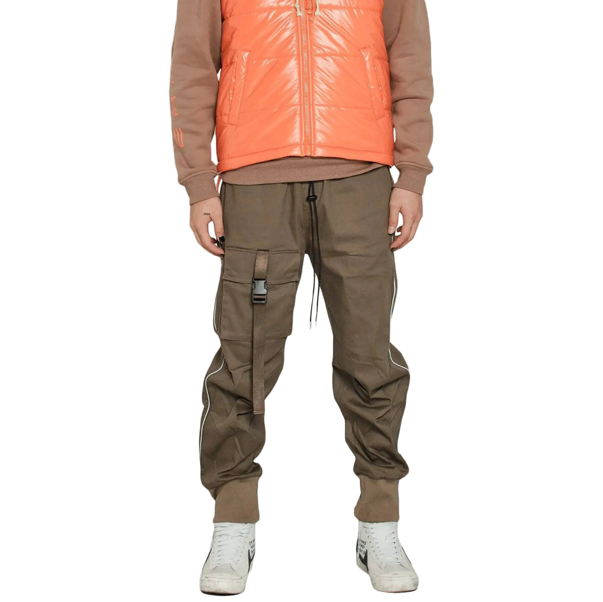 Person wearing a brown jacket, orange puffer vest, and brown cargo pants on a white background