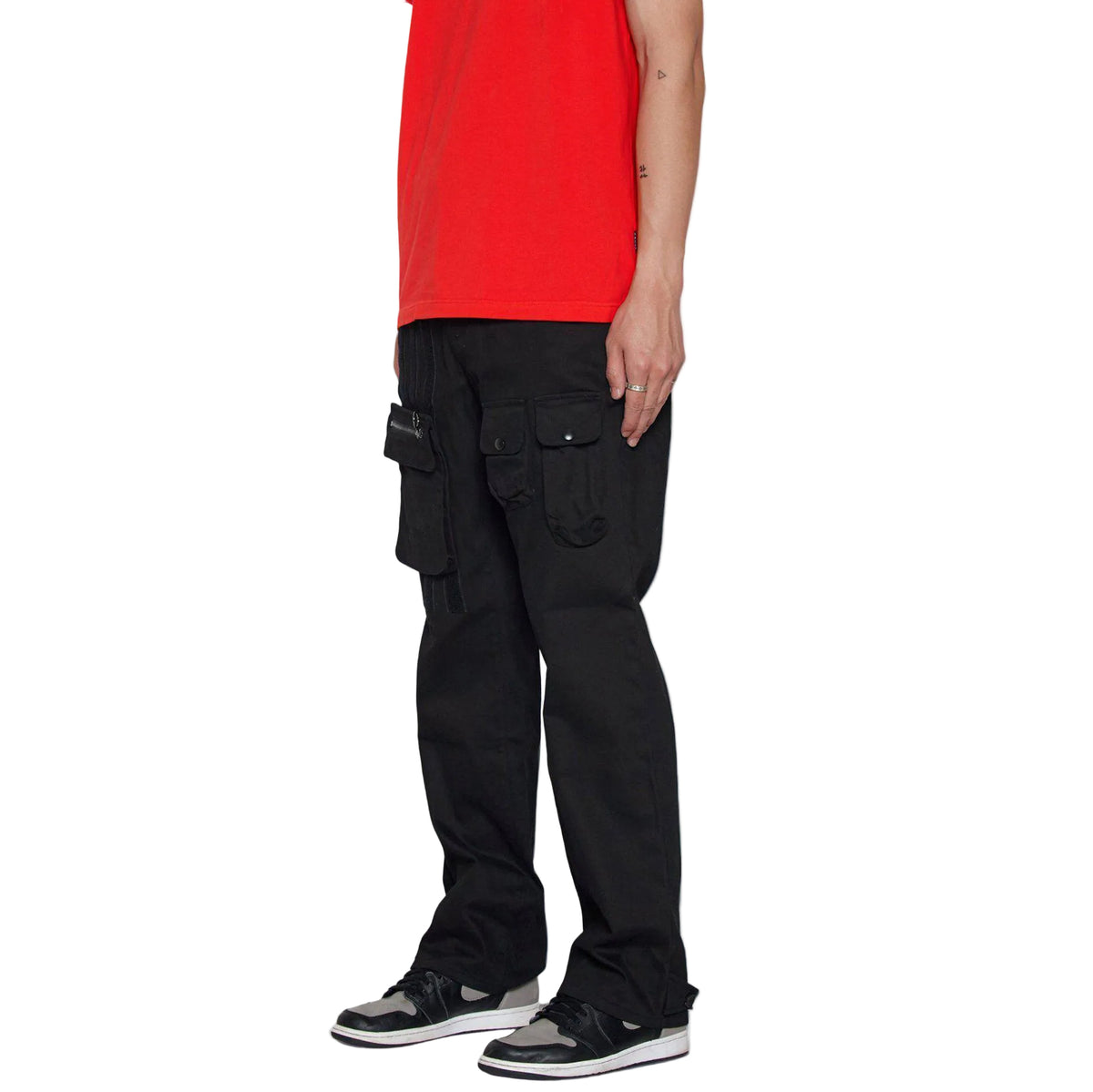Person wearing black cargo pants and a red shirt on a white background
