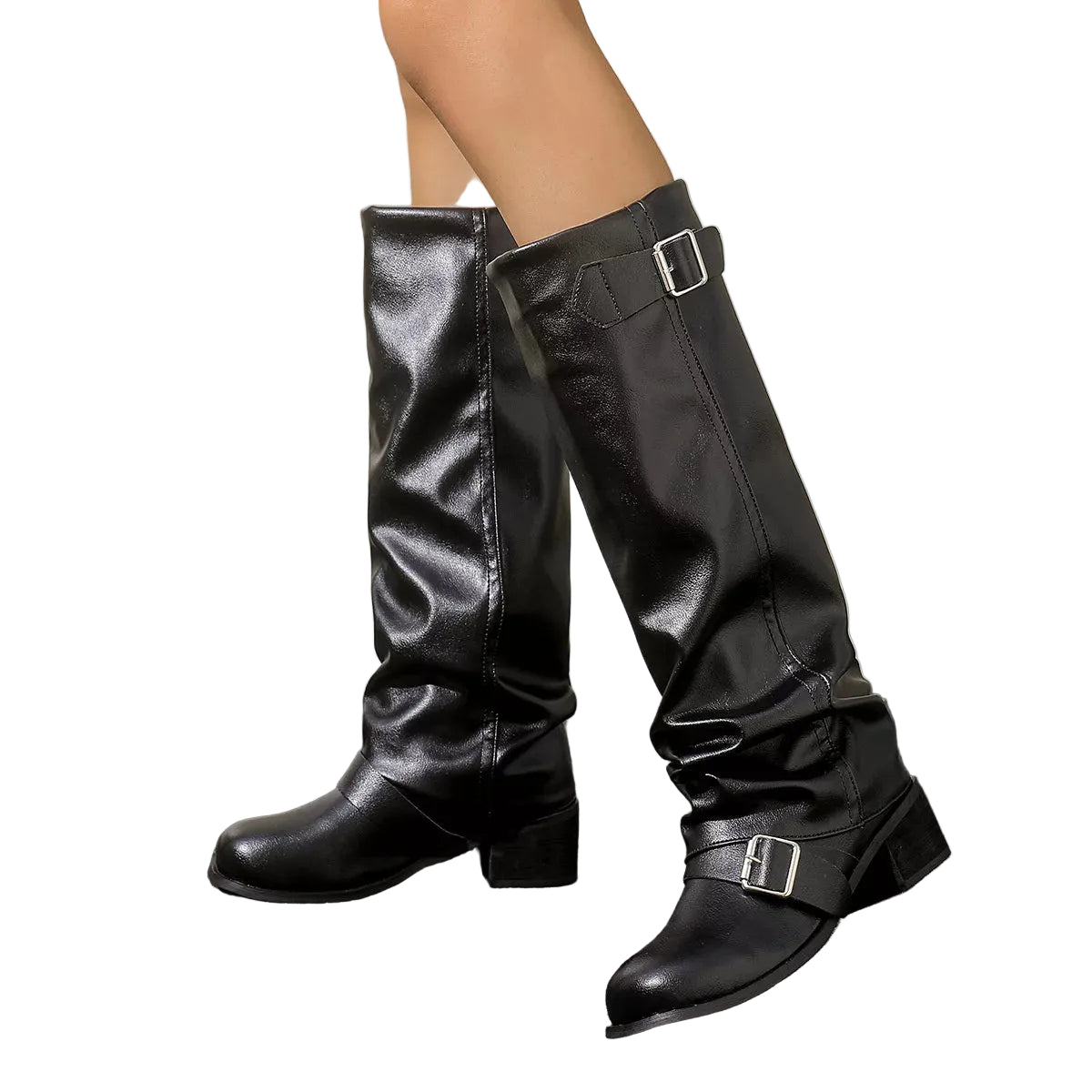A pair of black knee-high slouchy boots with silver buckle straps, shown on a model's legs against a neutral beige wall and dark gray floor.