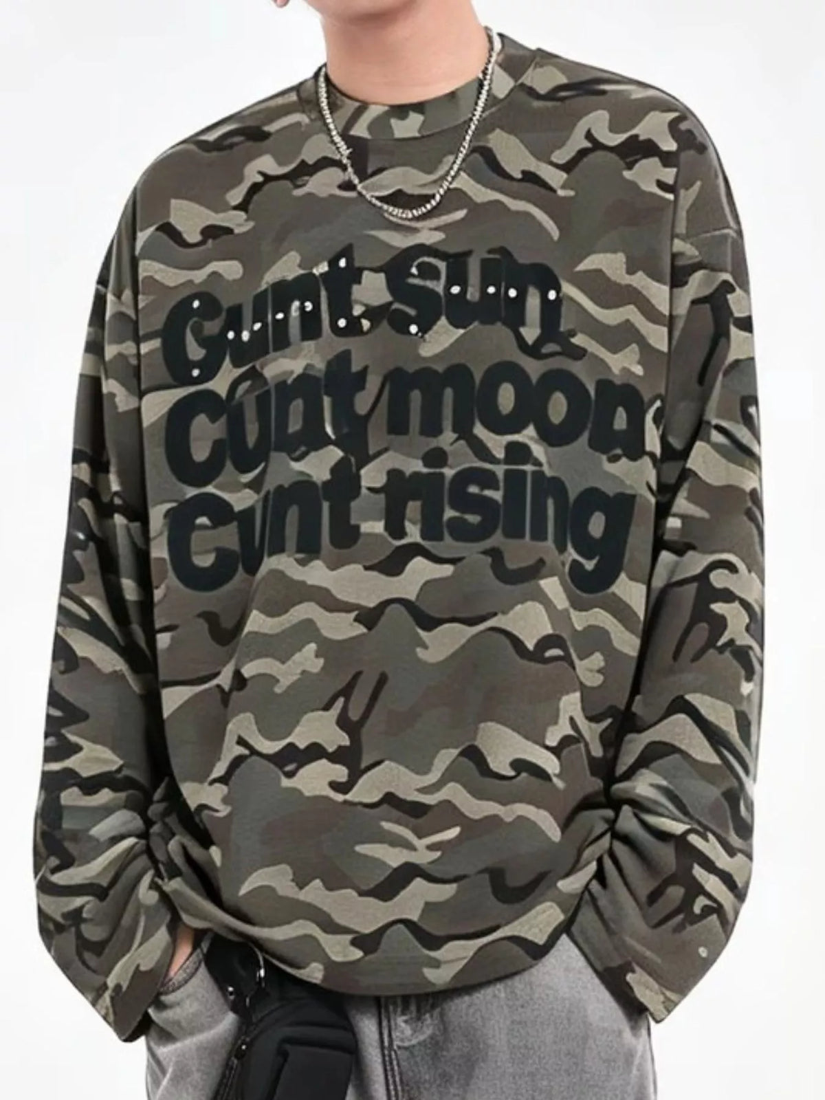 A person wearing a camouflage sweatshirt with the text 'Gunt sun Gunt moon Gunt rising' printed across the front in black. The sweatshirt features a green, brown, and gray camo pattern with black lettering.
