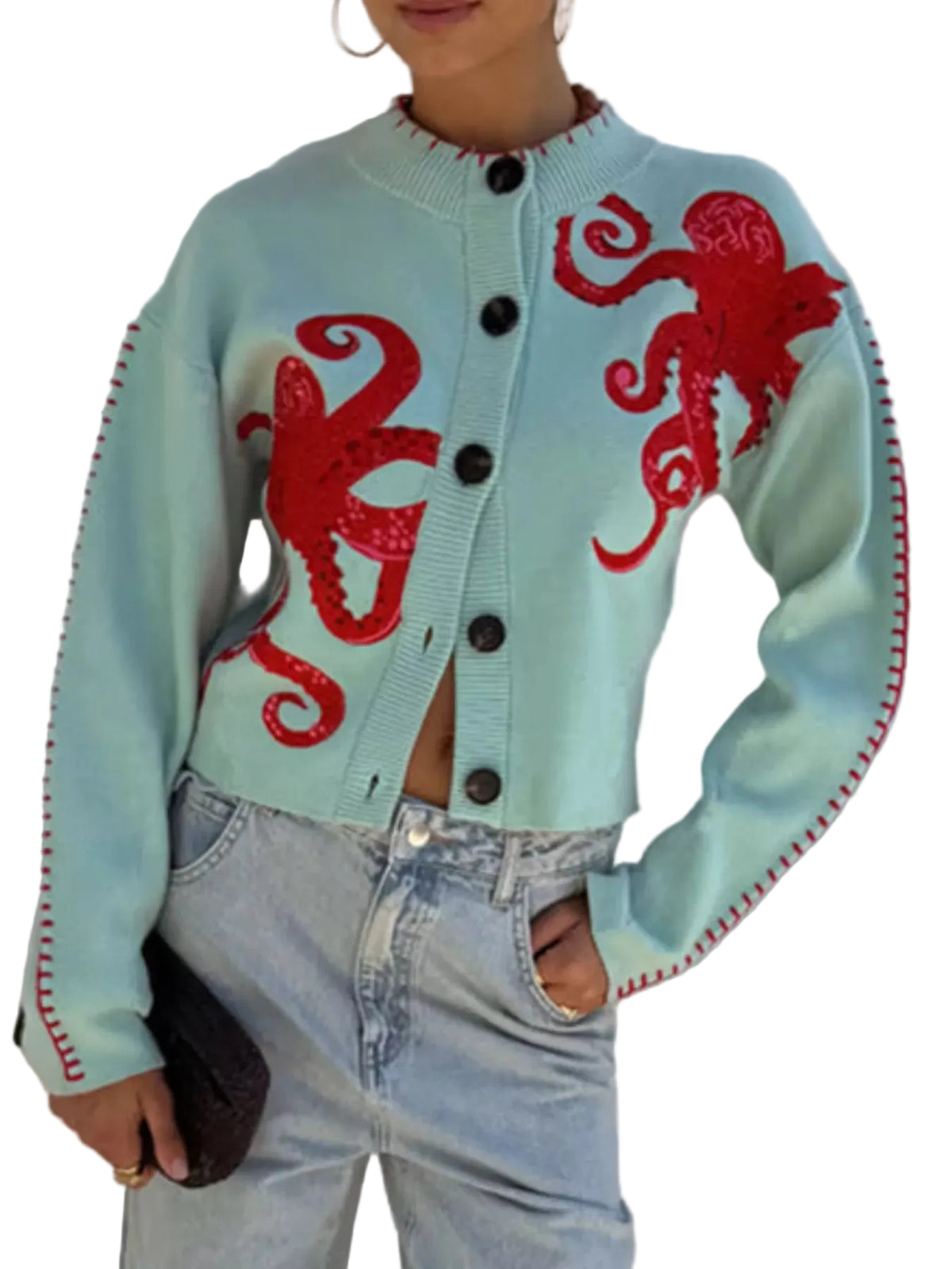 A person wearing a cropped light aqua knit cardigan with large red octopus motifs on the front and red stitched trim along the sleeves, paired with light blue jeans.
