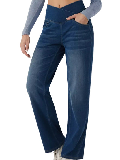 A person wearing dark blue high-waisted wide-leg jeans with a side pocket, paired with a gray long-sleeve top, shown from the waist down against a light gray background.