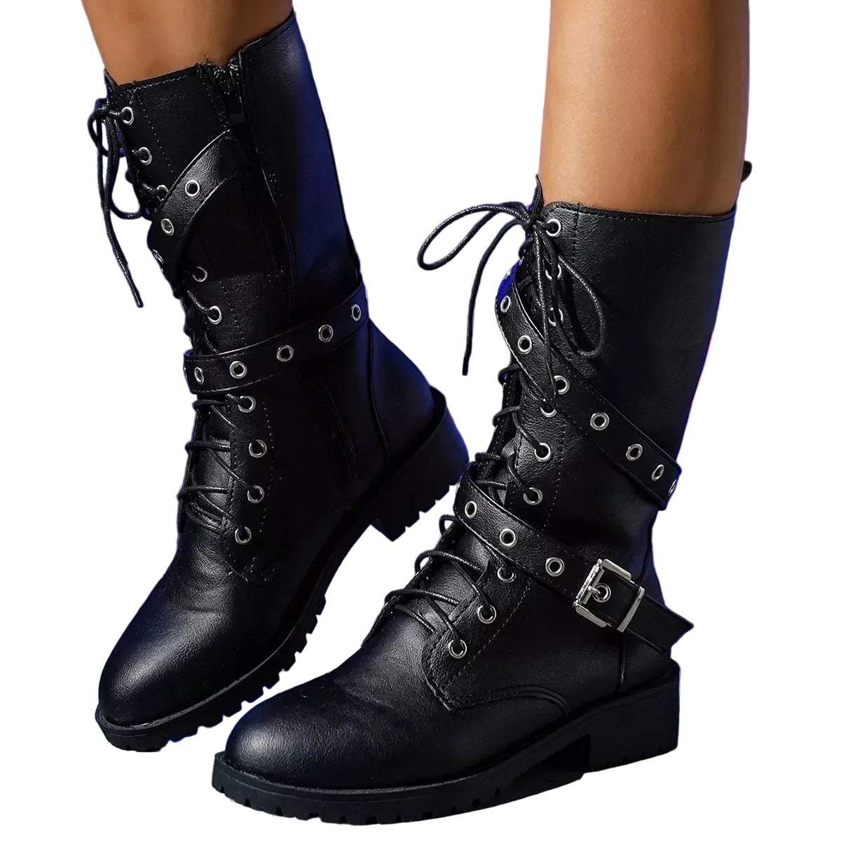 A pair of black leather lace-up combat boots with buckle straps and silver eyelets, shown on a model's feet against a dark blue neon-lit background.
