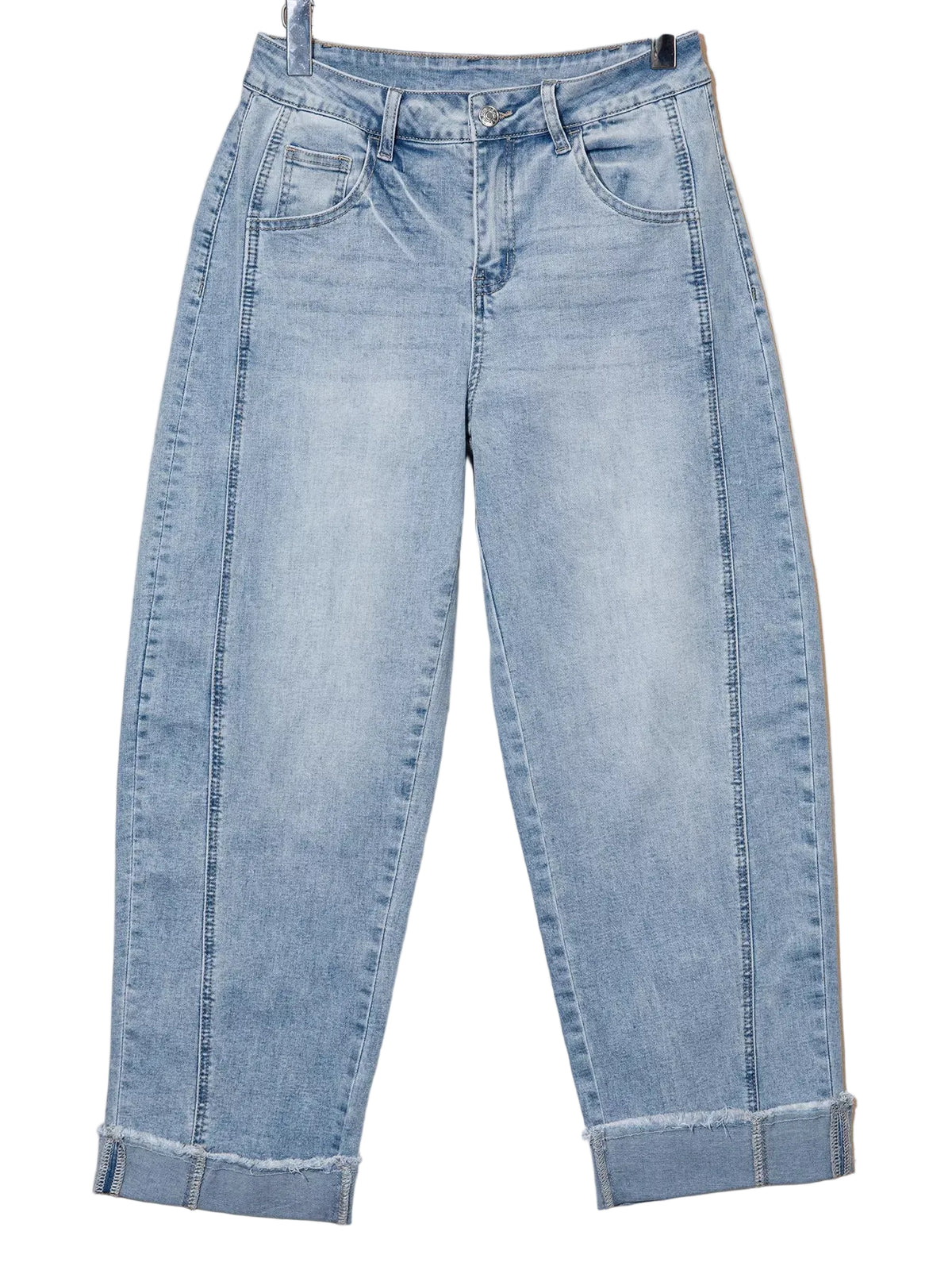 Light wash blue denim jeans with a cuffed ankle and raw hem, hanging against a plain beige background.