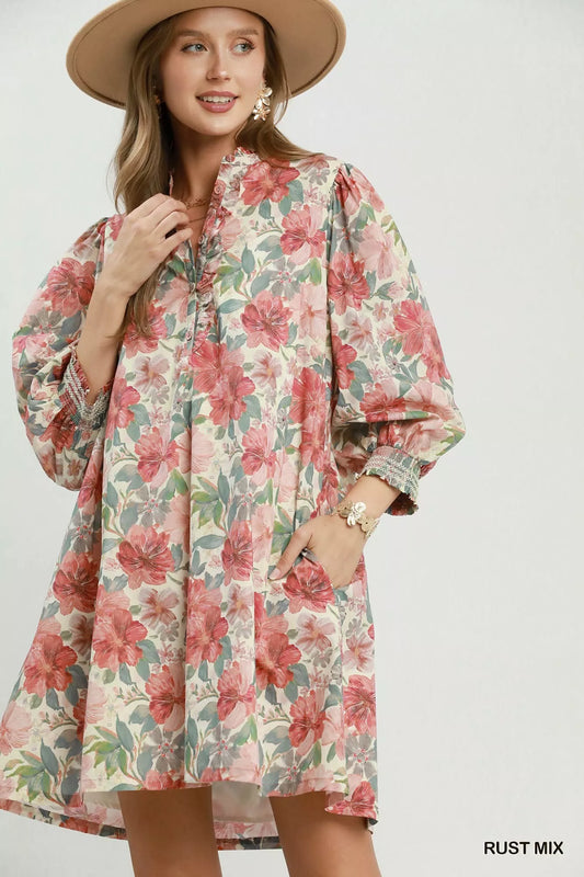 Woman wearing a floral dress with a rust mix color scheme on a white background