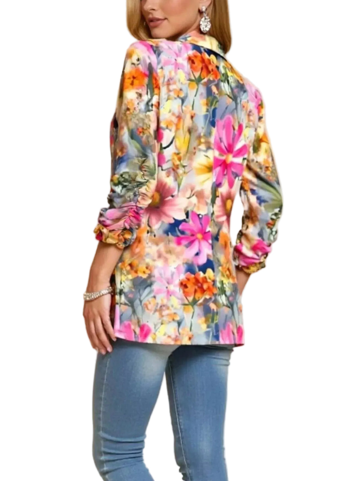 A woman wearing a colorful floral long-sleeve button-up shirt and blue jeans, shown from a side-back angle against a plain beige studio background.