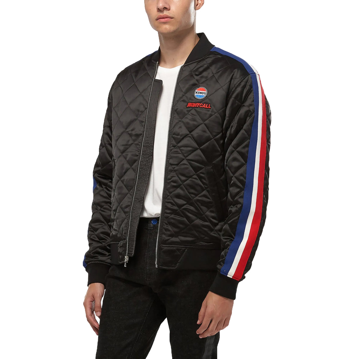 Person wearing a black quilted jacket with colorful stripes on a white background