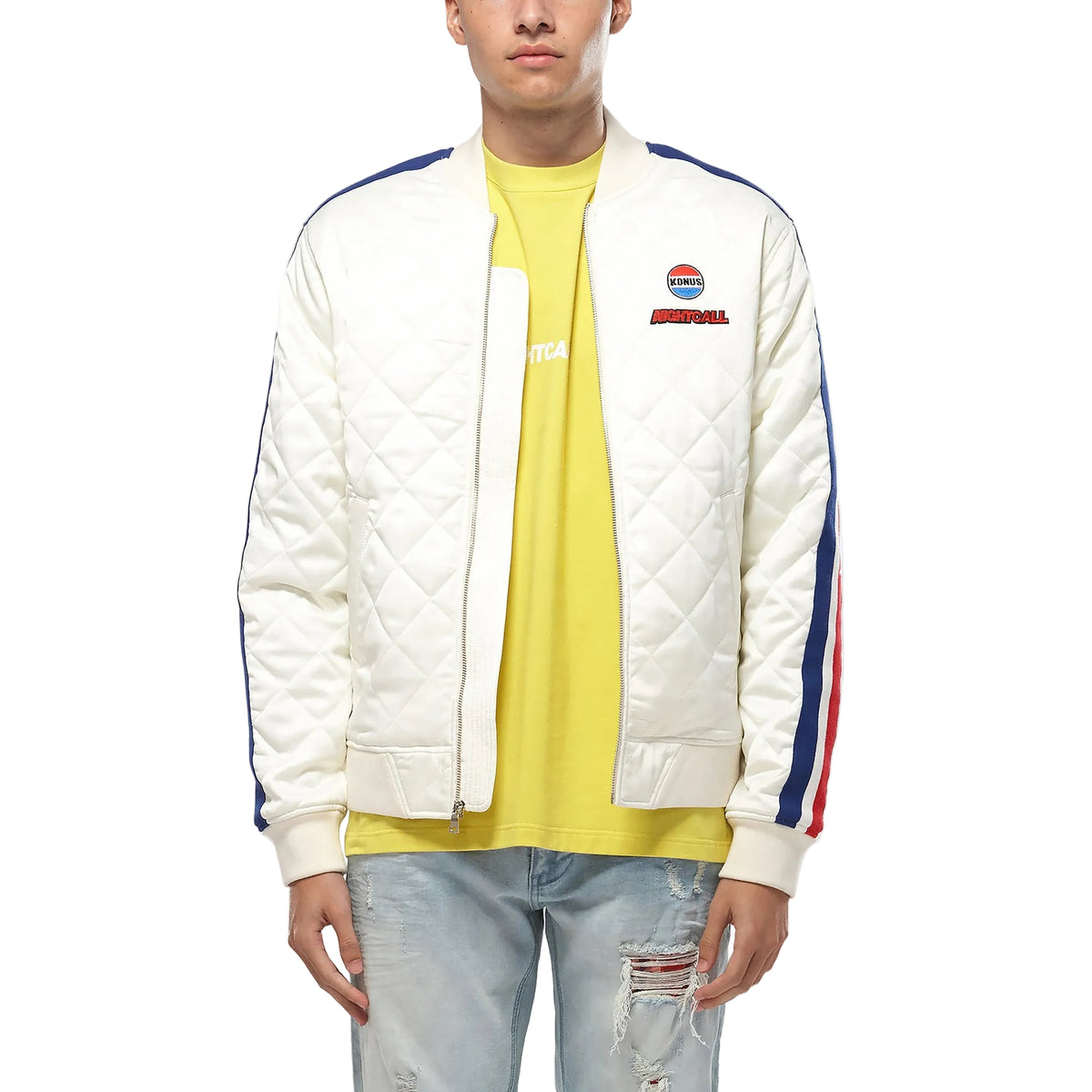 Person wearing a white quilted jacket with colorful stripes, yellow shirt, and light blue jeans on a white background