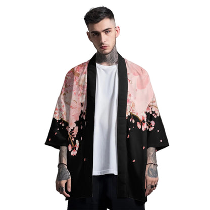 Man wearing a black kimono with pink floral patterns on a gray background