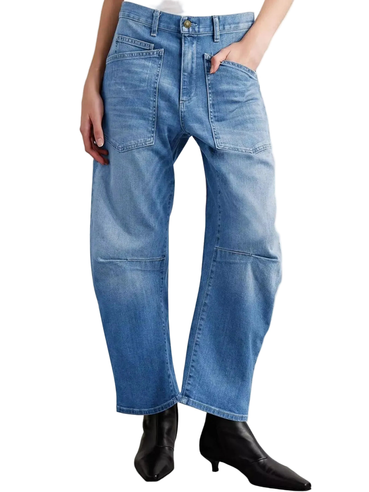 A person wearing light blue wide-leg denim jeans with front patch pockets and knee patch details, paired with black pointed-toe ankle boots against a plain white studio background.