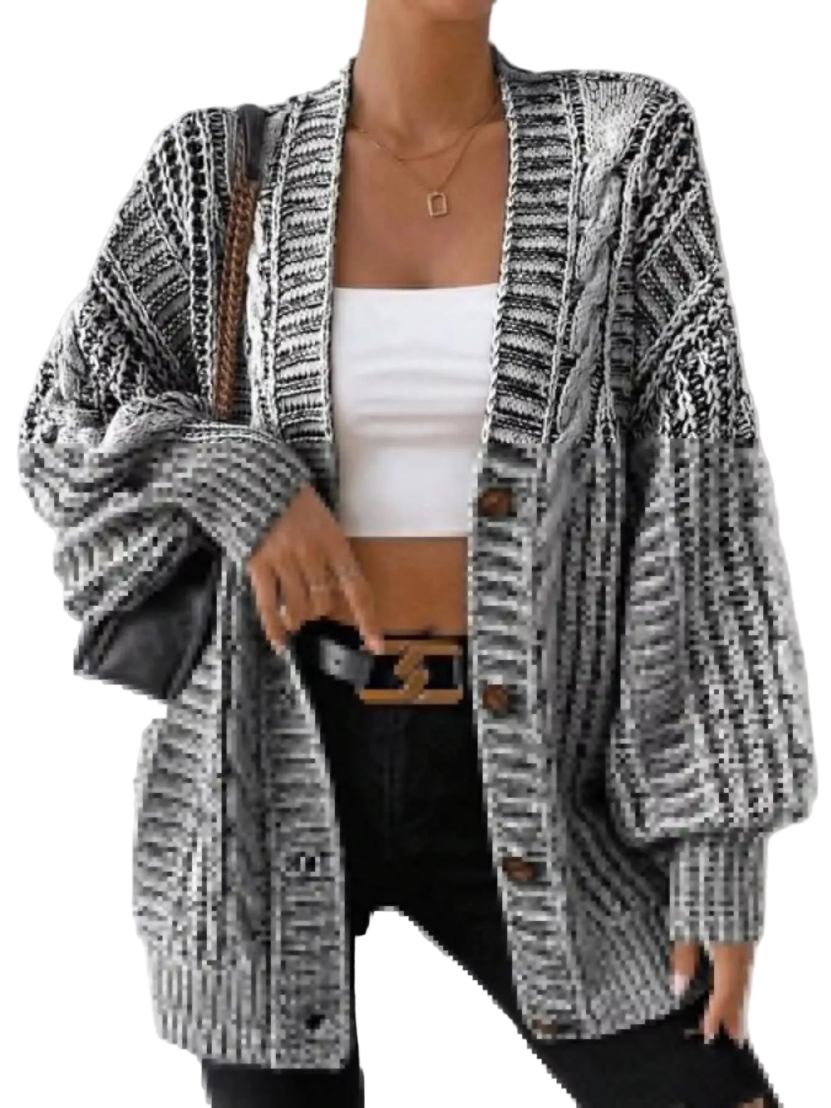 A woman wearing a black and white textured knit cardigan with balloon sleeves, a white crop top, and black pants, carrying a black shoulder bag.