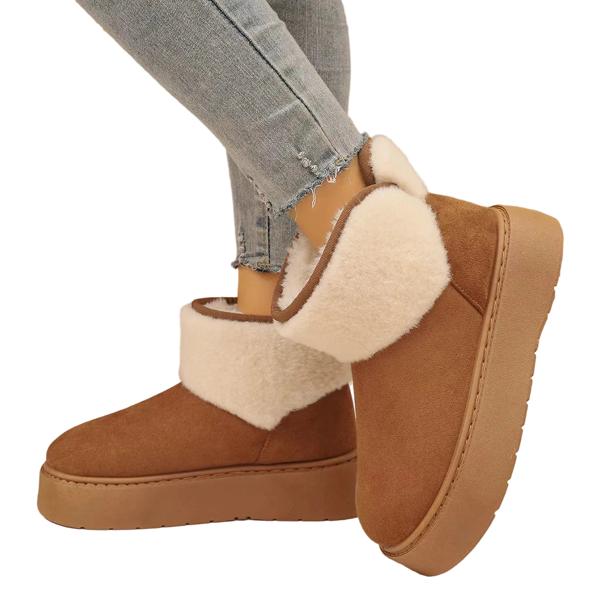 A pair of women's brown suede-like ankle boots with thick cream sherpa lining and platform soles, shown on a model wearing light-wash jeans against a textured beige wall.