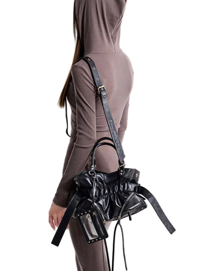 A model wearing a brown hooded long-sleeve top and matching pants, shown from the back and side, carrying a black patent leather shoulder bag with multiple straps and studded details against a light gray background.