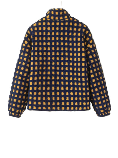 A textured, fuzzy quarter-zip fleece jacket with a yellow and navy blue checkered pattern, hanging on a white hanger against a plain beige wall.