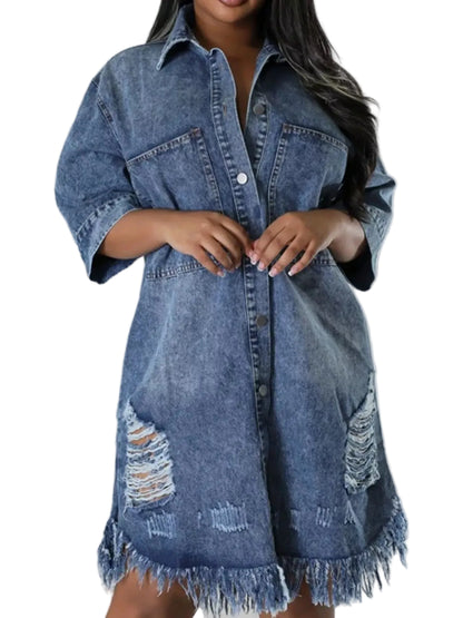 A plus-size model wearing a distressed blue denim shirt dress with frayed edges and ripped details on the front, shown against a plain light gray studio background.