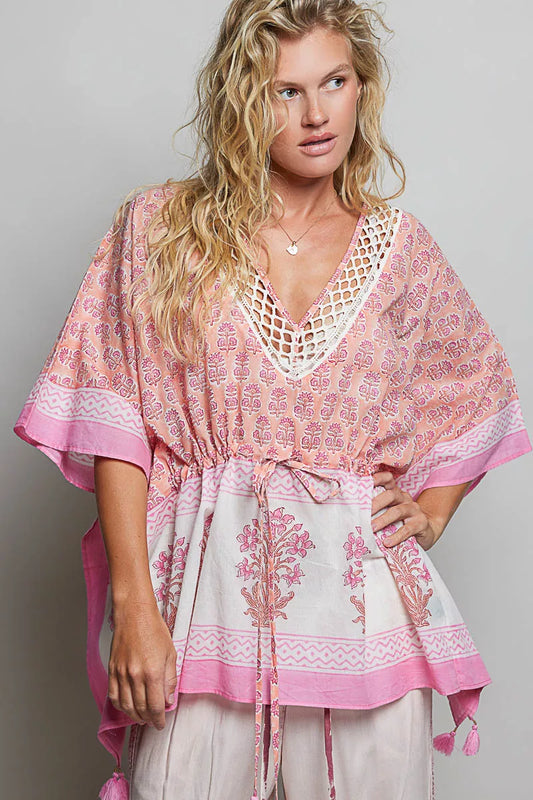 Woman wearing a pink and white patterned top with a gray background