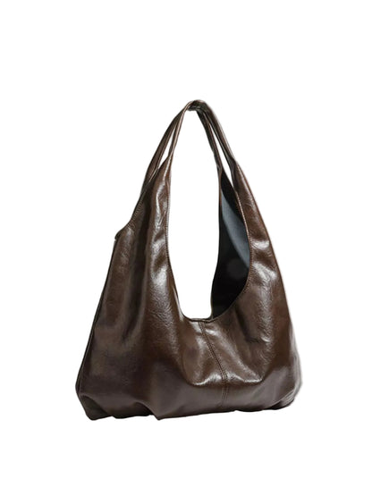 A dark brown slouchy leather hobo bag with a single shoulder strap, photographed on a light gray background.