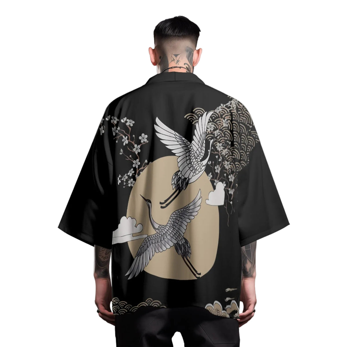 Person wearing a black kimono with crane and floral designs on a gray background