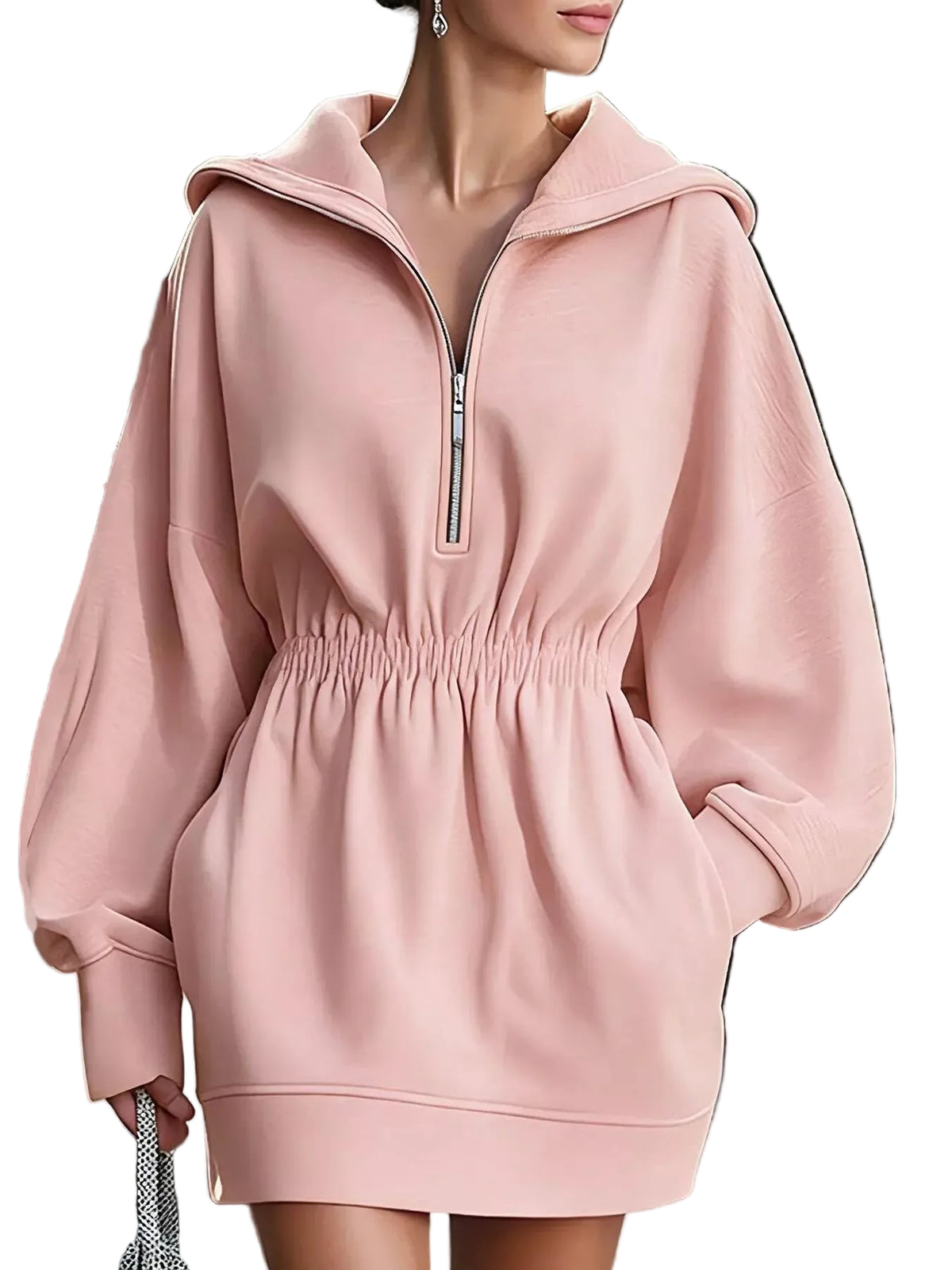 A woman wearing an oversized light pink pullover hoodie dress with a half-zip neckline, elastic waist, and long balloon sleeves, shown in a real outdoor setting.