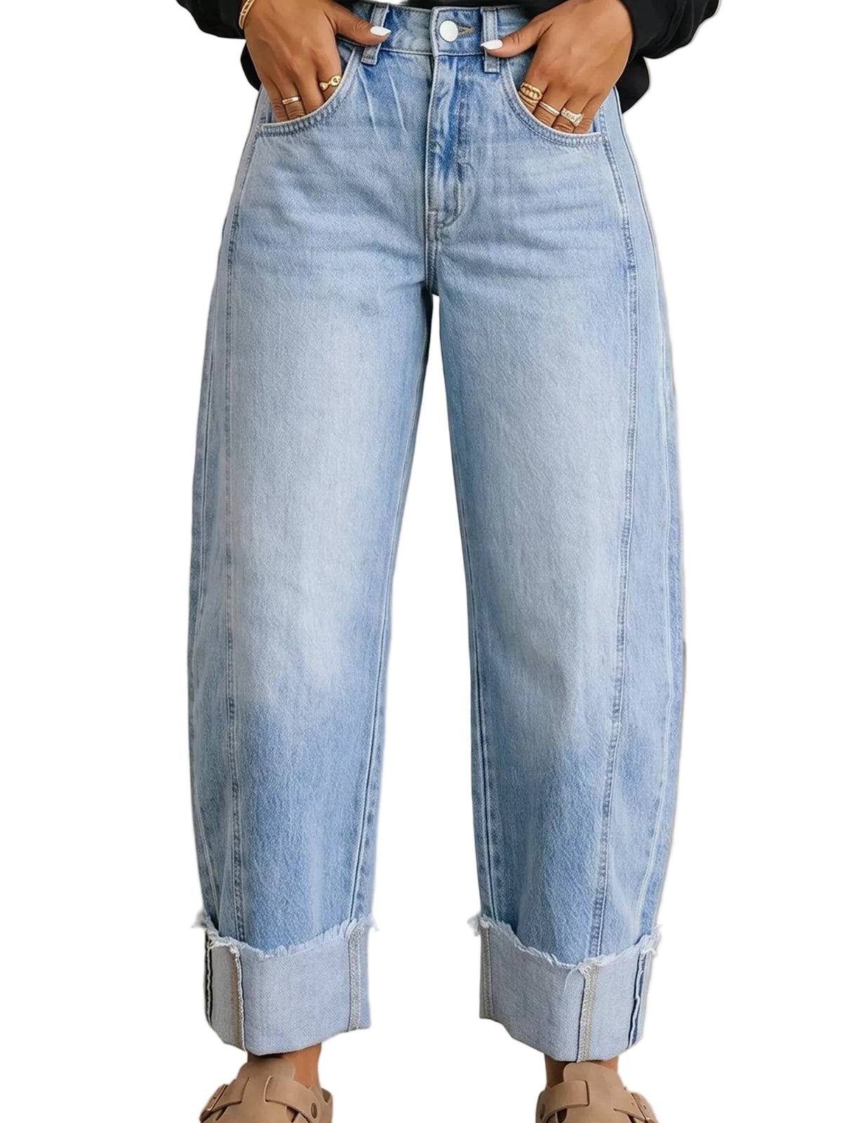 A person wearing light-wash blue wide-leg denim jeans with rolled cuffs, shown from the waist down in an indoor setting with a concrete floor.