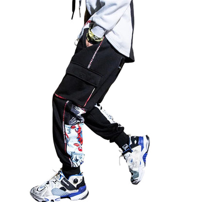 Person wearing black pants with colorful designs and white sneakers in an urban setting