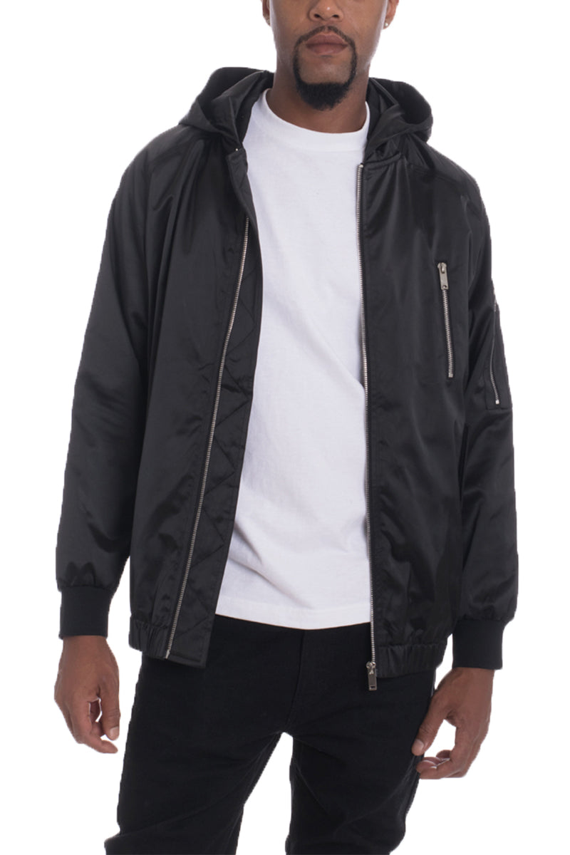 Man wearing a black jacket over a white shirt on a white background
