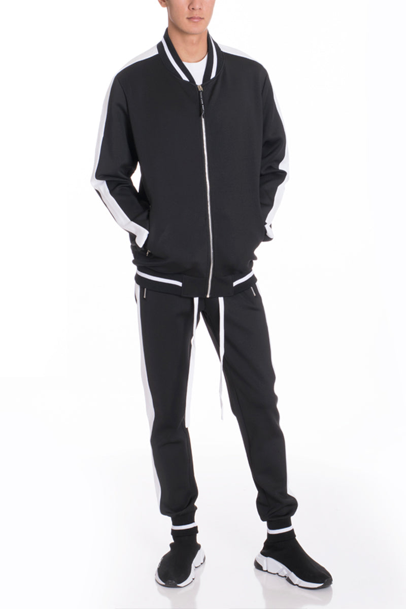 Person wearing a black tracksuit with white accents on a white background