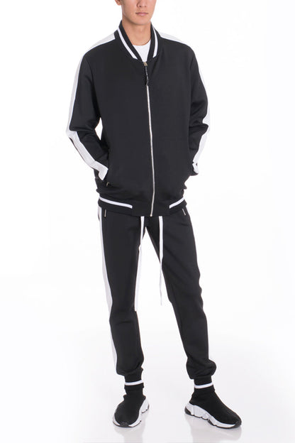 Person wearing a black tracksuit with white accents on a white background