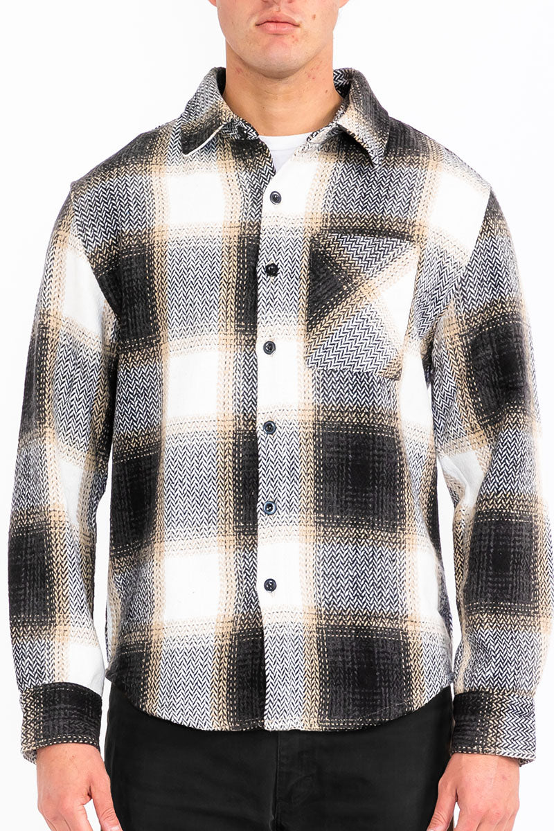 Person wearing a black and white plaid shirt with a white background