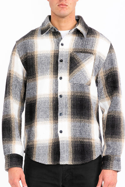 Person wearing a black and white plaid shirt with a white background