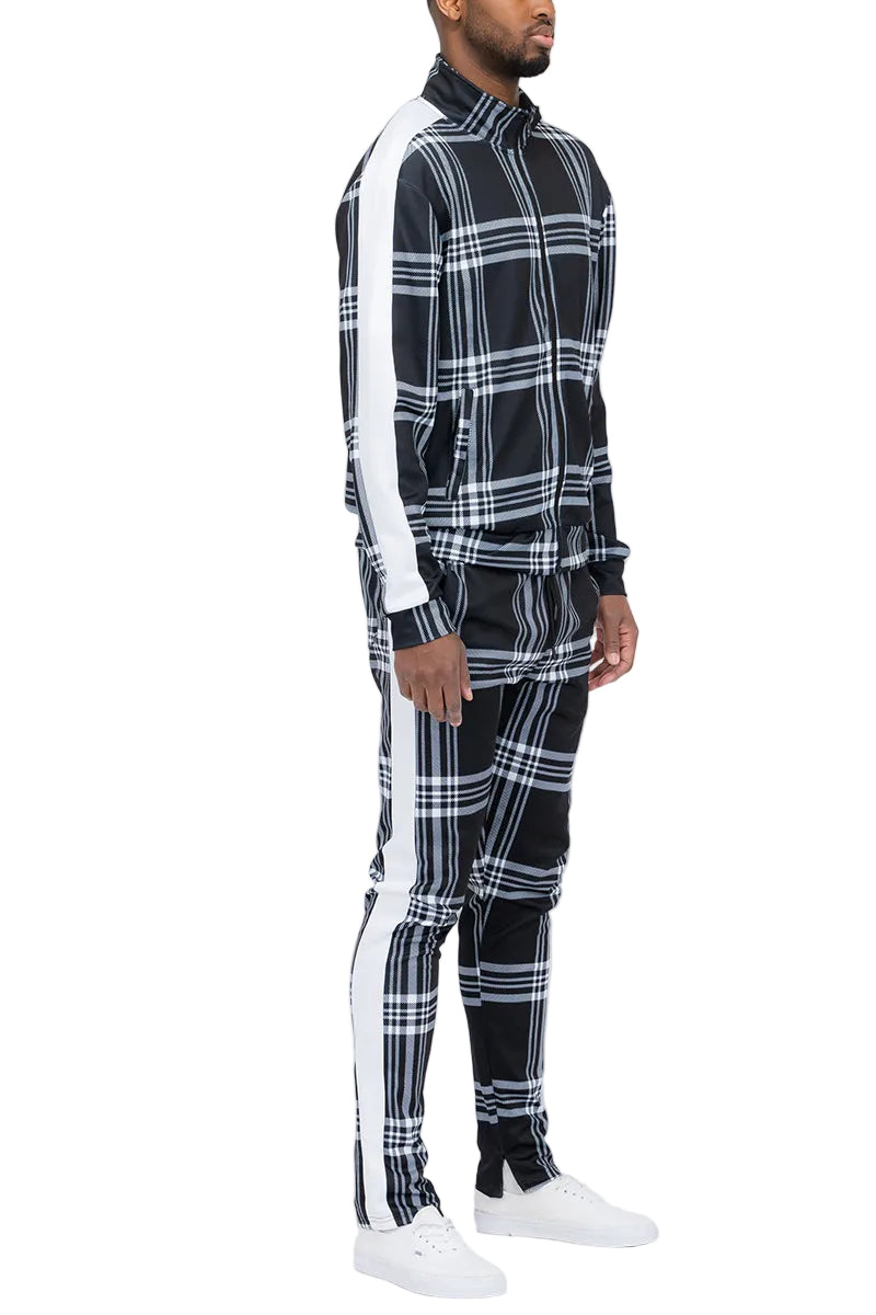 Person wearing a black and white plaid outfit with white sneakers on a white background