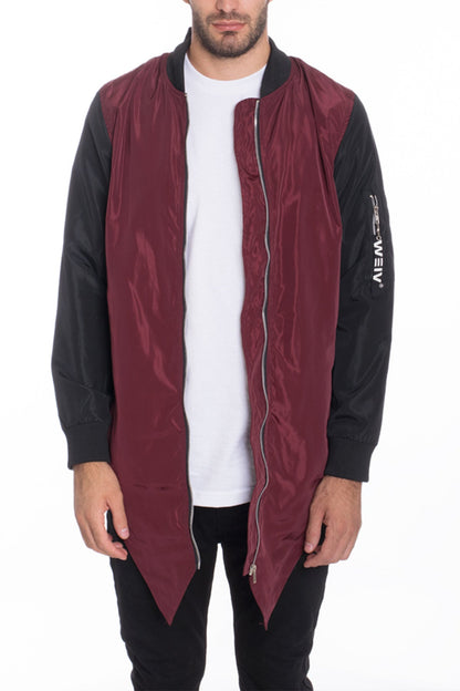 Man wearing a maroon and black jacket with a white shirt underneath on a white background