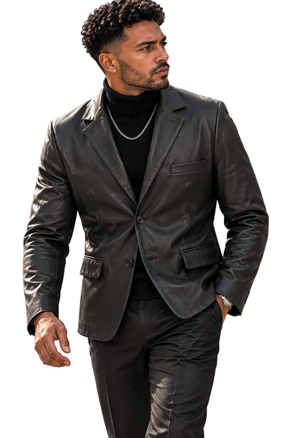 A man wearing a black leather blazer over a black turtleneck sweater and black trousers, walking outdoors on a city sidewalk.