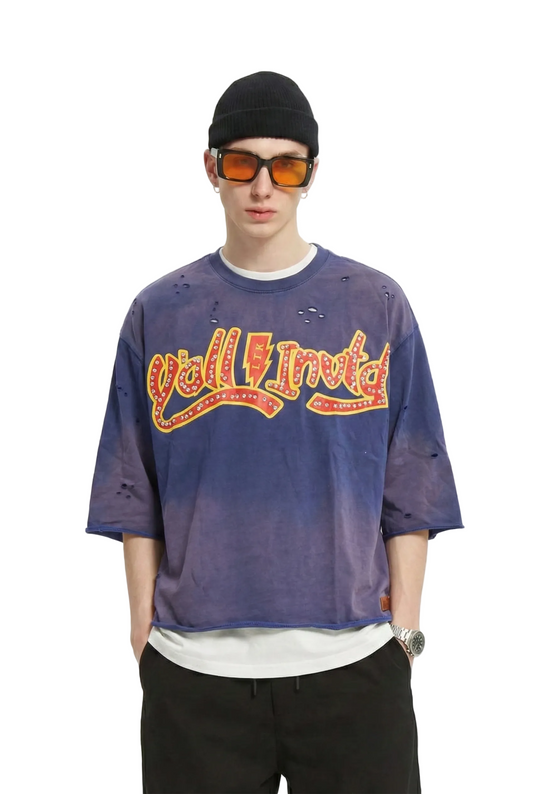 Person wearing a distressed t-shirt with a logo and text, sunglasses, and a cap on a white background