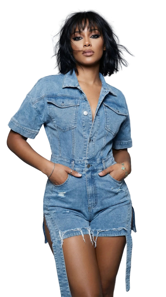 Woman wearing a denim romper against a gray background