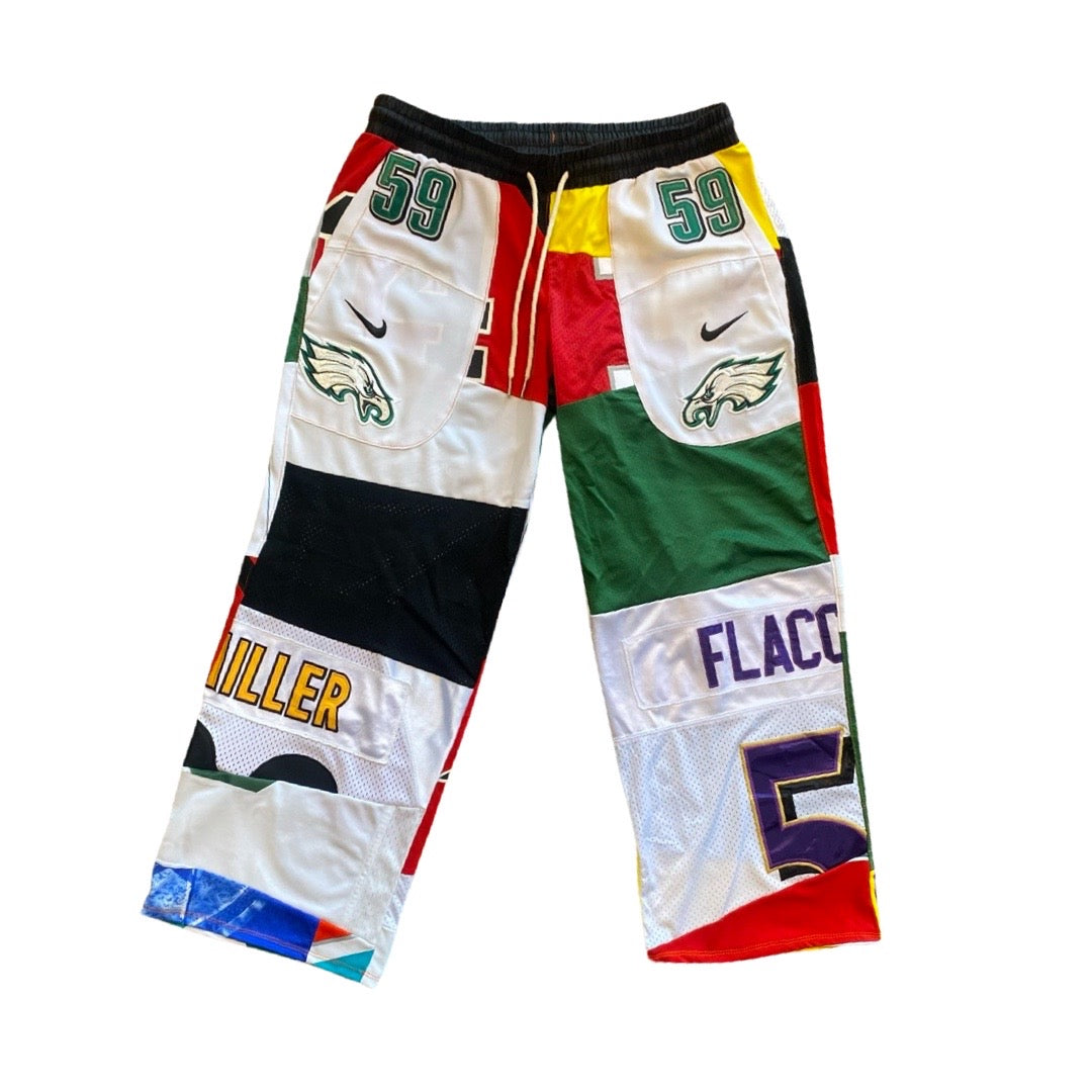 A pair of custom patchwork athletic shorts made from multiple Philadelphia Eagles jerseys, featuring white, green, red, black, and yellow panels with player names and numbers '59' and 'FLACC'.