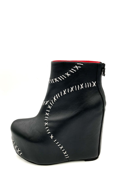 Black wedge shoe with white stitching on a white background